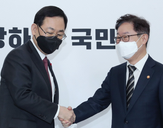 주호영 국민의힘 원내대표(왼쪽)가 8일 국회에서 예방을 온 박범계 법무부 장관과 악수하고 있다.  연합뉴스